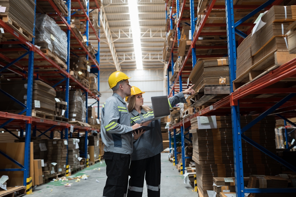 Modern warehouse with pallets, forklifts, and trucks representing storage and distribution services.